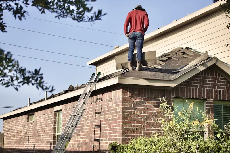 Professional roofer working on a residential roof in Tecumseh